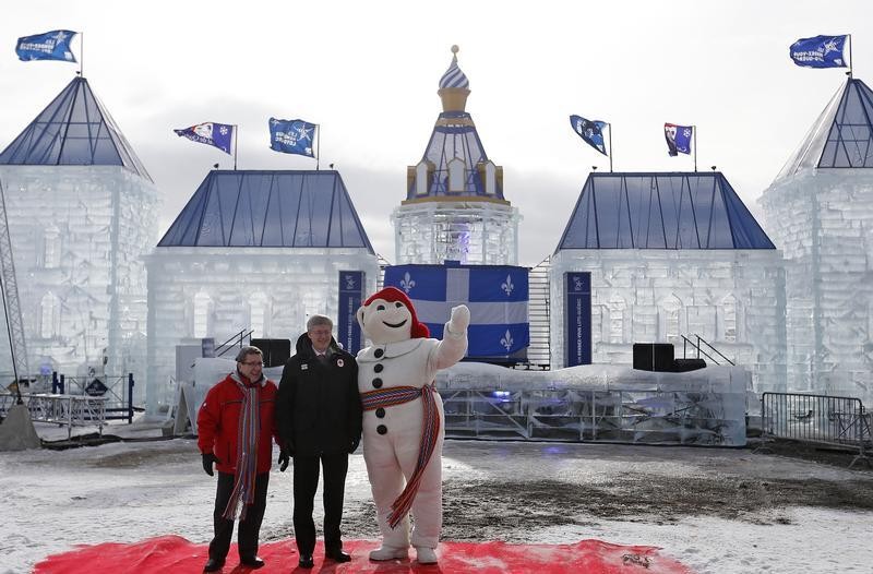 Canadas Prime Minister Stephen Harper C and Quebecs Mayor Regis Labeaume L pose for a photo with Bonhomme Carnaval, the official mascot of the Quebec Winter Carnival, on the Plains of Abraham in Quebec City, February 1, 2013.