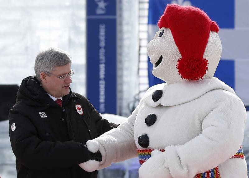 Canadas Prime Minister Stephen Harper L shakes hands with Bonhomme Carnaval, the official mascot of the Quebec Winter Carnival, on the Plains of Abraham in Quebec City, February 1, 2013.