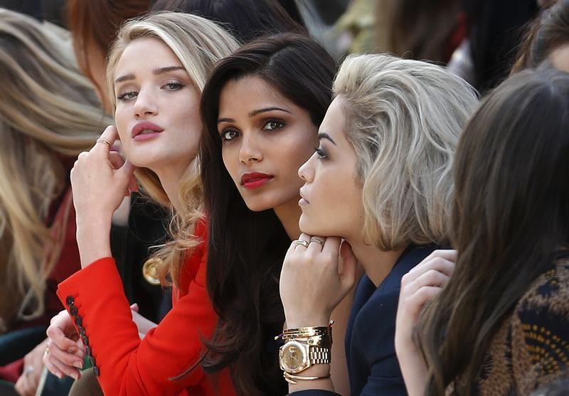 Model and actress Rosie Huntington-Whiteley L, actress Freida Pinto C and singer Rita Ora watch the presentation of the Burberry Prorsum AutumnWinter 2013 collection during London Fashion Week, February 18, 2013.