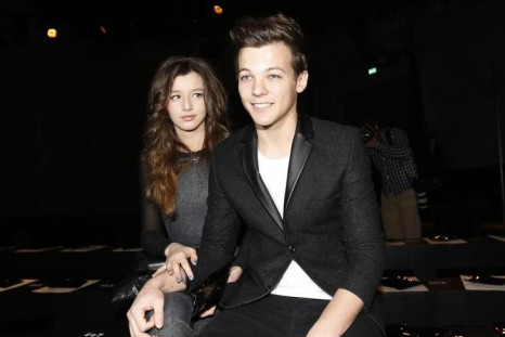 Performer Louis Tomlinson from One Direction sits with his friend in the front row at the Unique for Topshop Autumn/Winter 2013 collection during London Fashion Week, February 17, 2013.