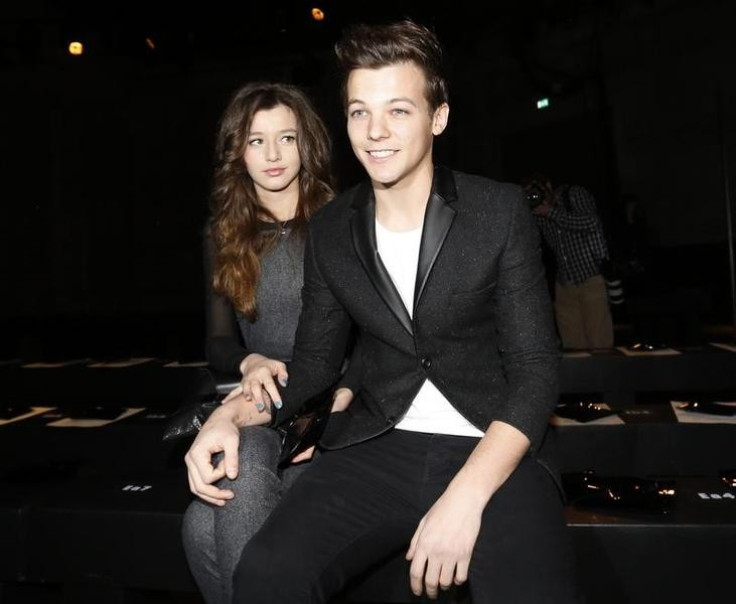Performer Louis Tomlinson from One Direction sits with his friend in the front row at the Unique for Topshop Autumn/Winter 2013 collection during London Fashion Week, February 17, 2013.