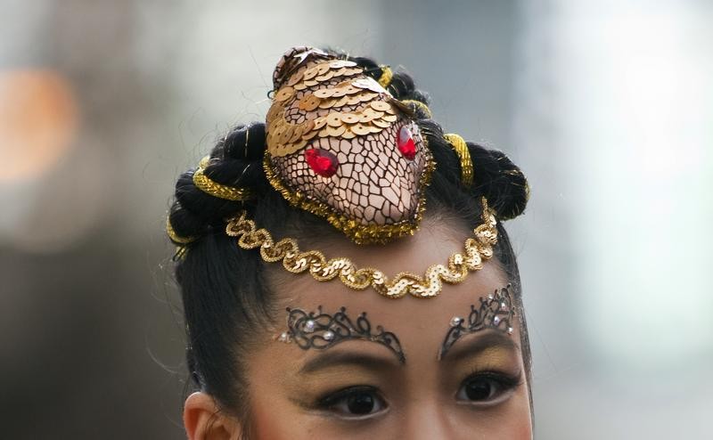 A girl wearing a hair piece shaped like a snake walks down a street during the Chinese New Year parade in Vancouver, British Columbia February 17, 2013. According to the Chinese zodiac, the Lunar New Year began on February 10 and marks the start of the Ye
