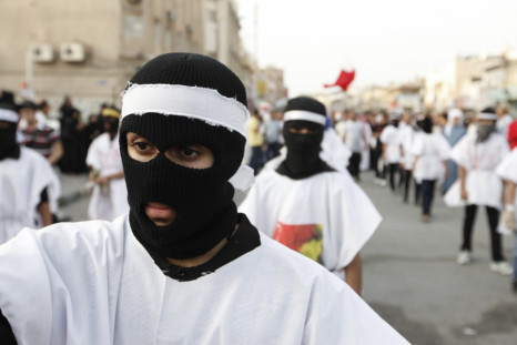 Protesters wearing burial shrouds take part in a procession during a visit to the grave of a 16-year-old youth killed by Bahraini security forces in clashes on February 14