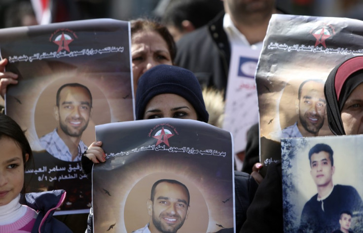 Palestinians hold placards depicting prisoner Samer al-Issawi, who has been on hunger strike for 209 days, during a protest in the West Bank city of Ramallah, calling for the release of Palestinian prisoners from Israeli jails, February 17, 2013. (Photo: