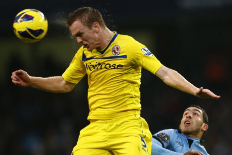 Alex Pearce heads the ball away from Carlos Tevez