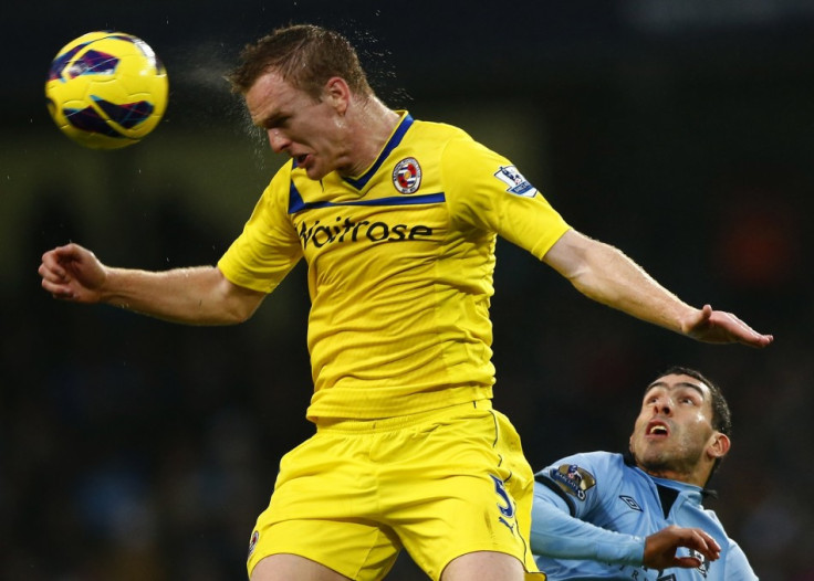 Alex Pearce heads the ball away from Carlos Tevez