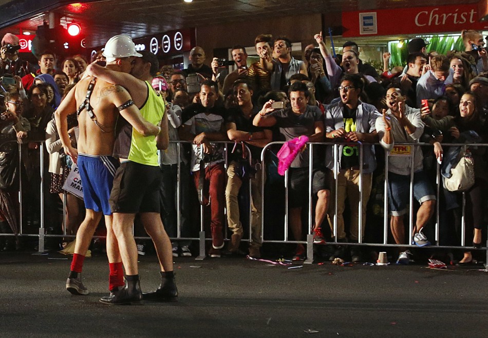 Spectators cheers as members of the group Gay Tradies kiss as they participate in the 35th annual Sydney Gay and Lesbian Mardi Gras parade March 2, 2013.