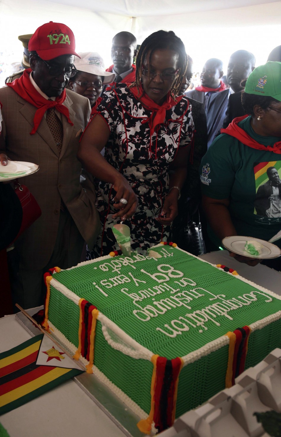 Zimbabwes President Robert Mugabe looks at his wife Grace cutting a cake during an event marking his 89th birthday at Chipadze stadium in Bindura, about 90 km 56 miles north of the capital Harare March 2, 2013. Addressing a rally to mark his 89th