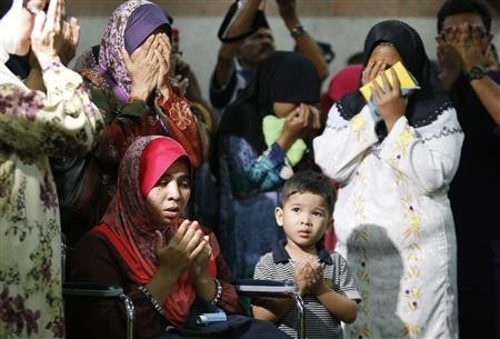 Noraziah Noor (seated L) and Nurunisa Abu Bakar (2nd R), the wives of the policemen killed