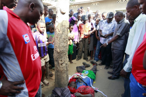 Kenyans look at the body of a member of the Mombasa Republican Council MRC who was shot dead at Mishomoroni area of the Kenyan Coast March 4, 2013