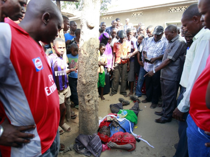 Kenyans look at the body of a member of the Mombasa Republican Council MRC who was shot dead at Mishomoroni area of the Kenyan Coast March 4, 2013