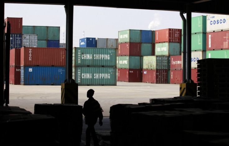 A worker walks in a shipping container area at the Port of Shanghai