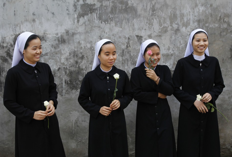 Catholic nuns hold roses while waiting for the arrival of Vaticans non-resident representative to Vietnam Archbishop Leopoldo Girelli at St. Teresa Cathedral of Hung Hoa diocese in Son Tay town, west of Hanoi November 25, 2011.