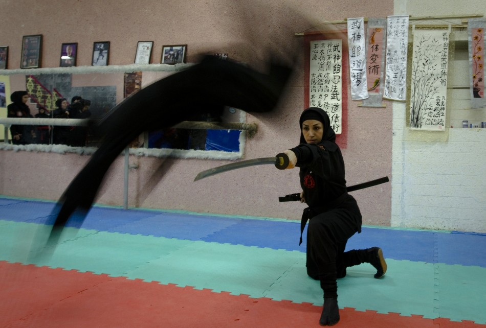 A Ninjutsu practitioner jumps over a sword as members of various Ninjutsu schools showcase their skills to the media in their gym at Karaj, 45 km 28 miles northwest of Tehran February 13, 2012.
