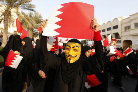 A female protester, wearing a Guy Fawkes mask, holds a Bahraini paper flag in an anti-government rally in Budaiya, west of Manama March 1, 2013.