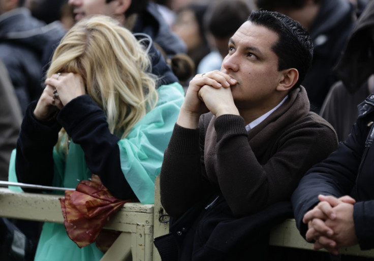 Faithful react while waiting for smoke to rise from a chimney on top of the Sistine Chapel during the second day of voting for the election of a new pope, at the Vatican March 13, 2013. Roman Catholic Cardinals will continue their conclave meeting inside