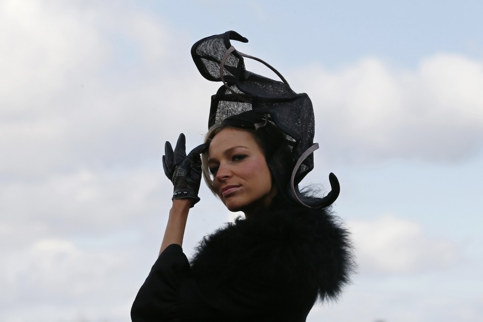 Racegoer Victoria Ilina poses in her hat on Ladies Day, the second day of racing at the Cheltenham Festival horse racing meet in Gloucestershire, western England March 13, 2013.