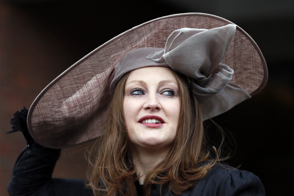 Racegoer Camilla Bassett-Smith poses in her hat on Ladies Day, the second day of racing at the Cheltenham Festival horse racing meet in Gloucestershire, western England March 13, 2013.