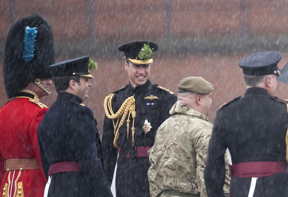 Britains Prince William C stands in the rain during a visit to Mons Barracks in Aldershot, southern England March 17, 2013. Prince William attended the St Patricks Day Parade as Colonel of the Regiment, and his wife Catherine, Duchess presen