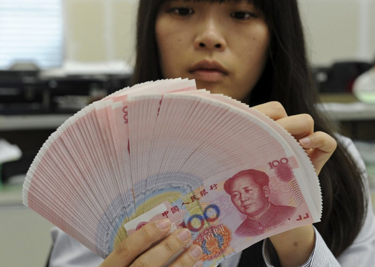 Employee counting Chinese yuan notes in a bank