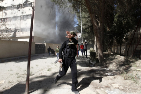 A fighter from the Islamist Syrian rebel group Jabhat al-Nusra reacts as a picture is taken of him as their base is shelled in Raqqa provinc