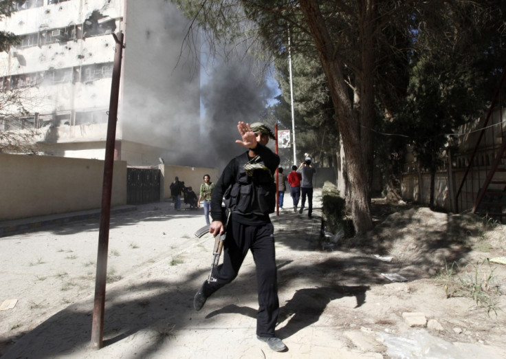 A fighter from the Islamist Syrian rebel group Jabhat al-Nusra reacts as a picture is taken of him as their base is shelled in Raqqa provinc