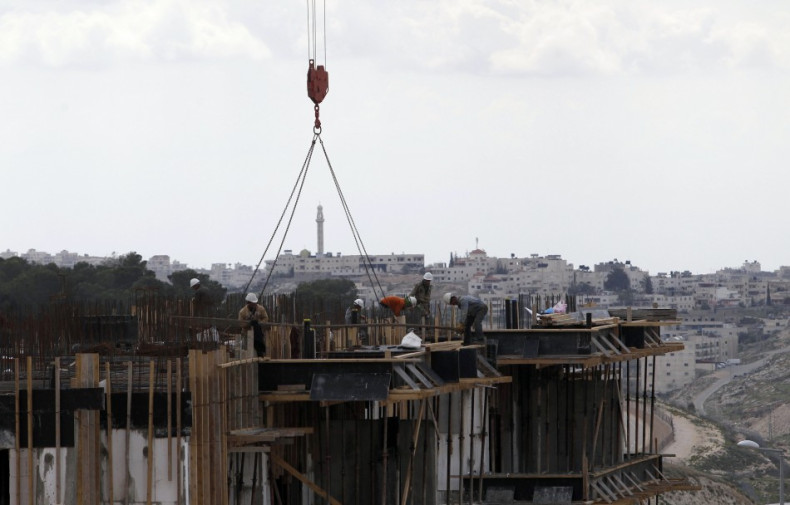 he West Bank town of Bethlehem is seen in the background as Palestinian labourers work on a construction site at a Jewish settlement near Jerusalem known to Israelis as Har Homa and to Palestinians as Jabal Abu Ghneim March 18, 2013. Israel's new housing