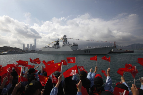 Members of the public wave Chinese and Hong Kong flags as the Chinese naval guided missile frigate Yuncheng (571) arrives at the Ngong Shuen Chau Naval Base in Hong Kong