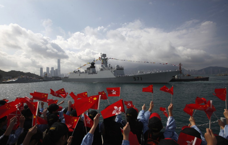 Members of the public wave Chinese and Hong Kong flags as the Chinese naval guided missile frigate Yuncheng (571) arrives at the Ngong Shuen Chau Naval Base in Hong Kong