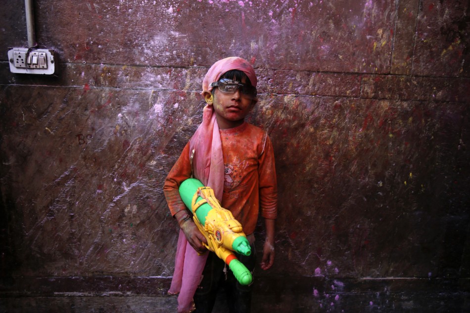 A boy poses for a picture with a water gun during holi celebrations at the Bankey Bihari temple in Vrindavan in the northern Indian state of Uttar Pradesh March 26, 2013. Holi, also known as the Festival of Colours, heralds the beginning of spring and is
