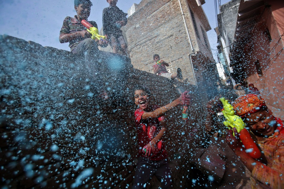 A boy sprays coloured foam during Holi celebrations in a lane near the Bankey Bihari temple in Vrindavan, in the northern Indian state of Uttar Pradesh March 26, 2013. Holi, also known as the Festival of Colours, heralds the beginning of spring and is cel