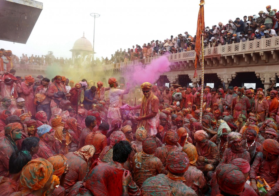 People throw coloured powder as they celebrate Lathmar Holi at Nandgaon village in the northern Indian state of Uttar Pradesh, March 22, 2013. In a Holi tradition unique to Nandgaon and Barsana villages, men sing provocative songs to gain the