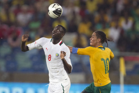 Cheikhou Kouyate (L) battles for the ball with South Africa's Steven Pienaar