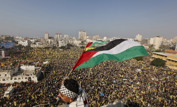 A boy waves a Palestinian flag during a rally marking the 48th anniversary of the founding of the Fatah movement,