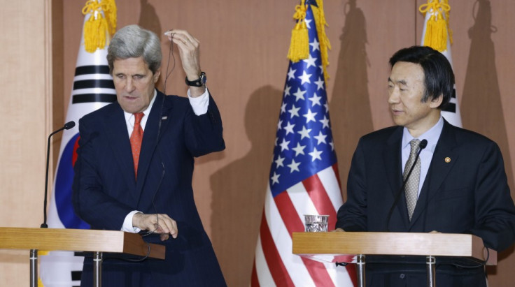 U.S. Secretary of State John Kerry (L) adjusts an earphone during a news conference with South Korean Foreign Minister Yun Byung-se