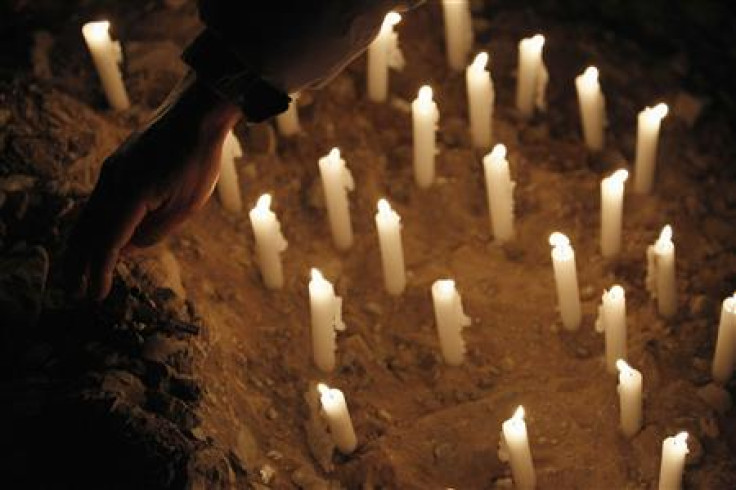 Alberto Segovia, brother of Dario Segovia, one of 33 miners trapped underground in a copper and gold mine, picks up a rosary as he prays outside the mine in Copiapo