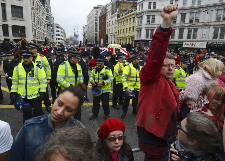 Demonstrators turn their backs as the funeral procession of Margaret Thatcher travels towards St Paul's Cathedral (Reuters)