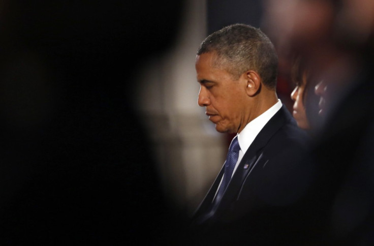 U.S. President Barack Obama and first lady Michelle Obama pray during an interfaith memorial service