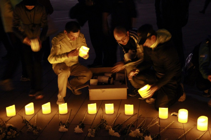 People set up candles and flowers as they pray for victims of Monday's Boston Marathon bombings