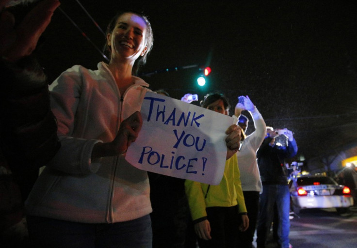 Members of the public cheer as police officers leave the scene where Dzhokhar Tsarnaev, the surviving suspect in the Boston Marathon bombings, was taken into custody