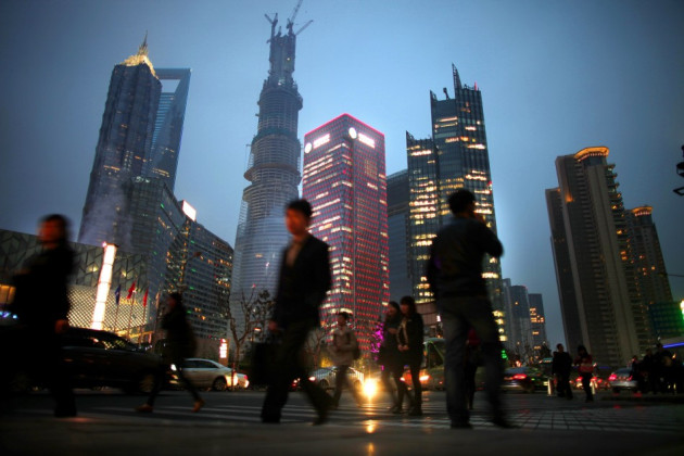 People walk along a busy street at Pudong financial district in Shanghai People walk along a busy street at Pudong financial district in Shanghai