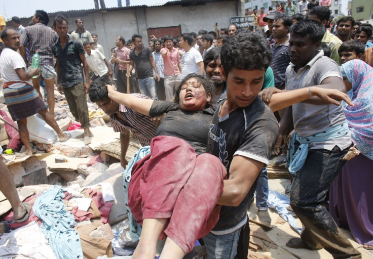 People rescue a garment worker who was trapped under the rubble of the collapsed Rana Plaza building
