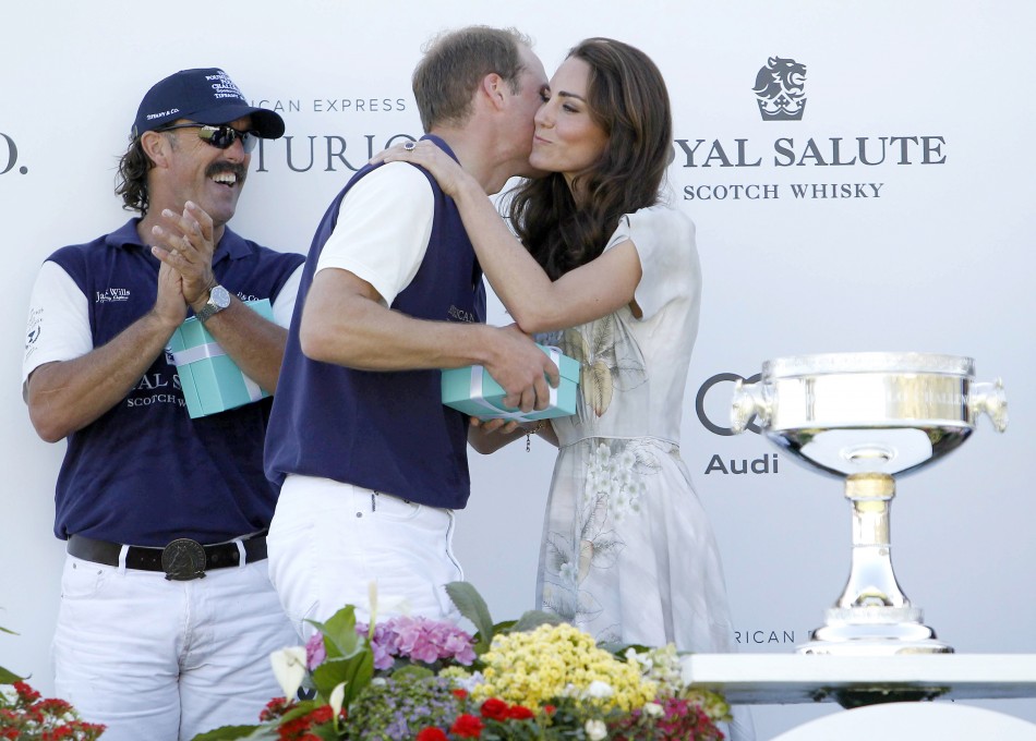 Catherine, the Duchess of Cambridge, kisses her husband, Prince William, while his teammate Santi Trotz L applauds as she presents awards following a polo match at the Santa Barbara Polo and Racquet Club for a charity event held in support of the Americ