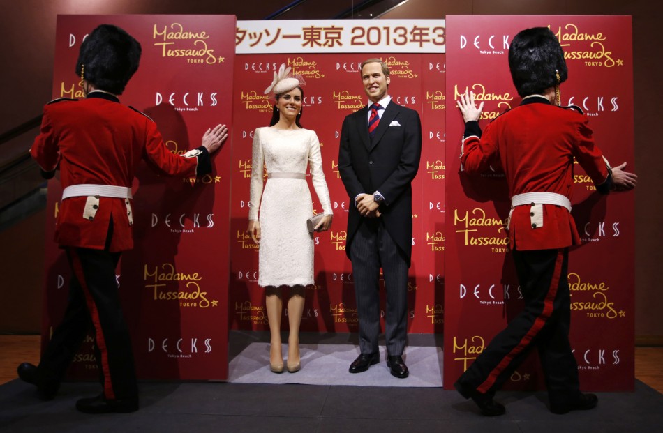 Wax figures of Prince William and his wife Catherine, Duchess of Cambridge, are unveiled by models wearing costumes depicting the Queens guards, during a media briefing for the opening of the Madame Tussauds Tokyo wax museum, in Tokyo November 28, 2