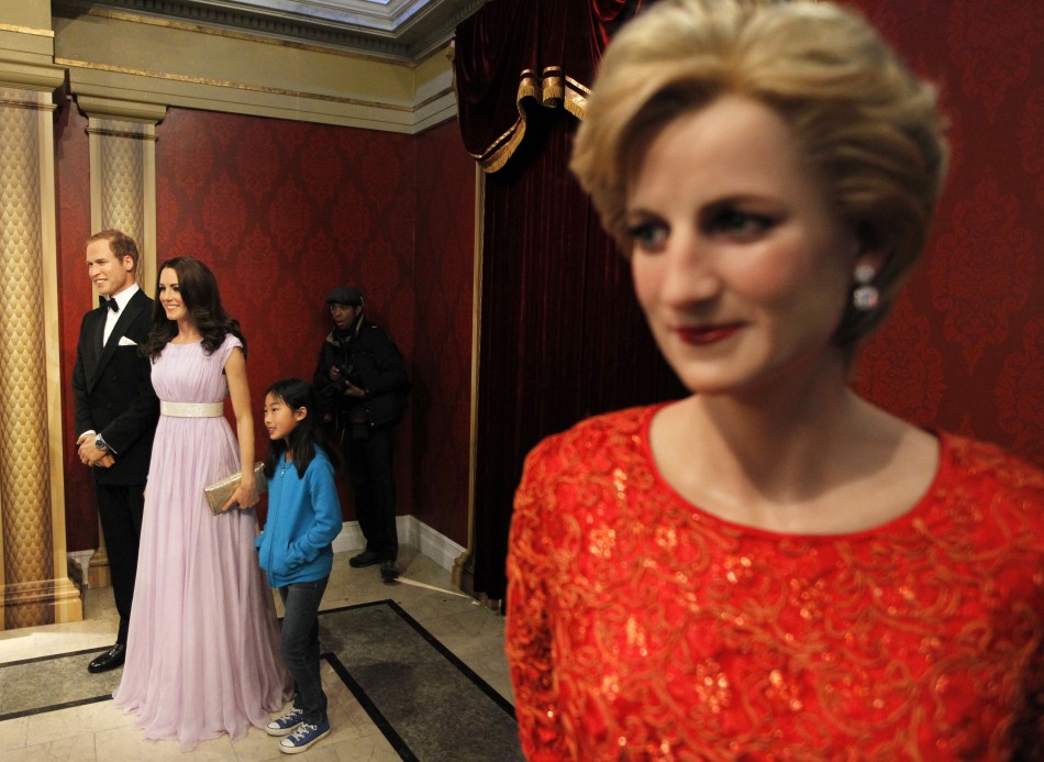 Visitors pose with wax models of Britains Royal couple William and Catherine, the Duke and Duchess of Cambridge, at Madame Tussauds in New York, April 4, 2012.