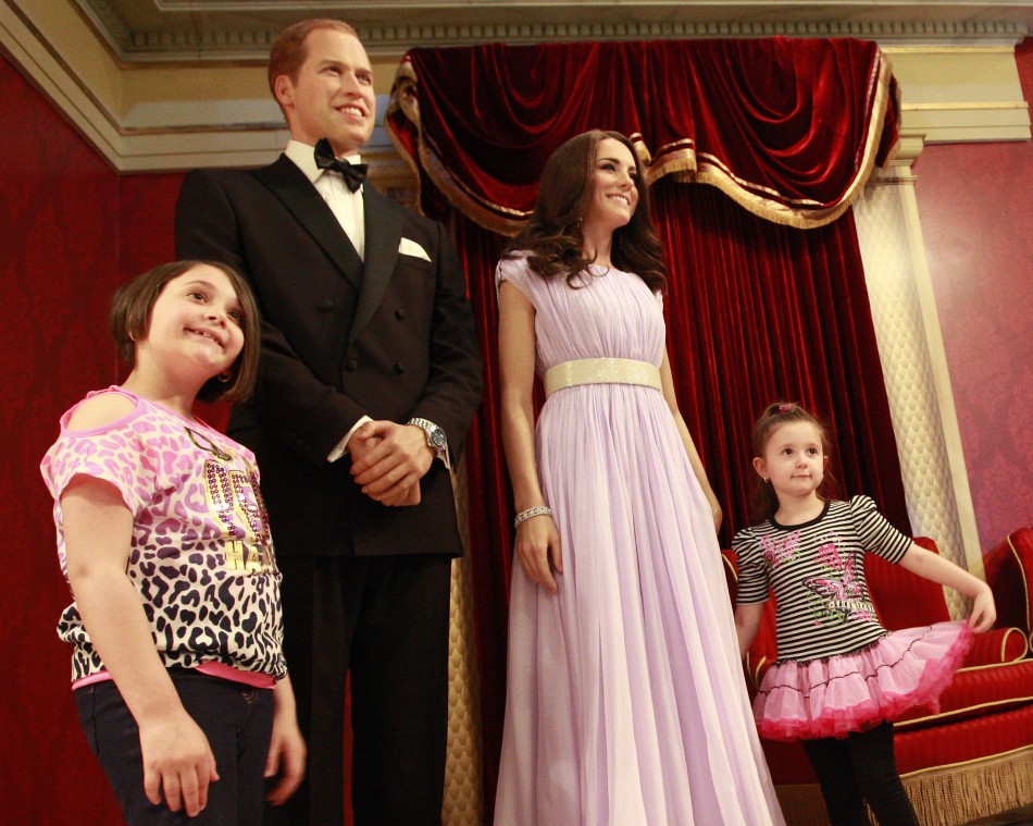 Visitors pose with wax models of royal couple William and Catherine, the Duke and Duchess of Cambridge, at Madame Tussauds in New York, April 4, 2012.