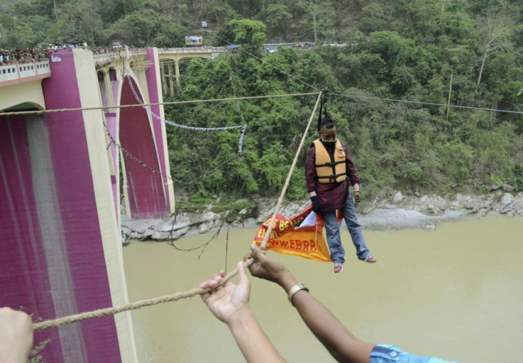 Sailendra Nath Roy, a Guinness World Record holder, is seen hanging from a rope after performing a stunt over the Teesta river