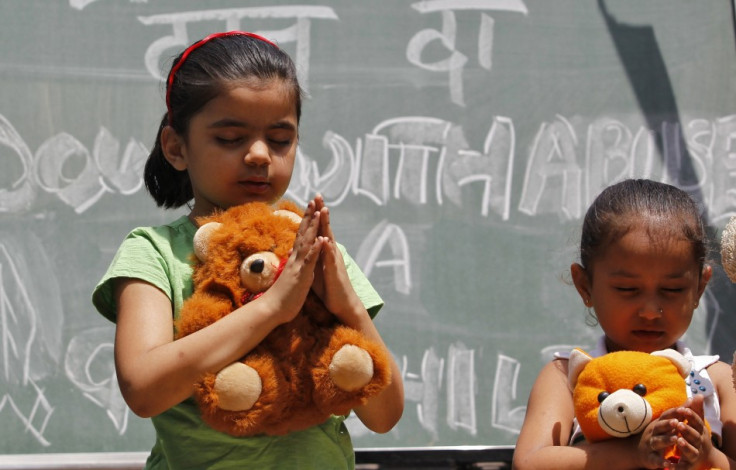 Children pray for the five-year-old victim of a New Delhi attack