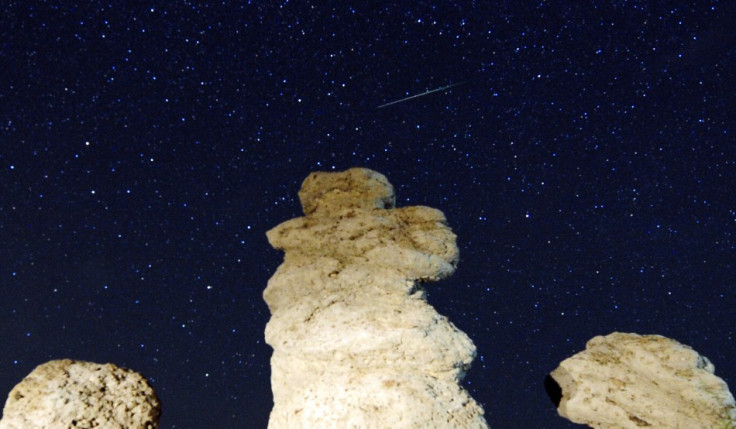 A meteor streaks past stars in the night sky