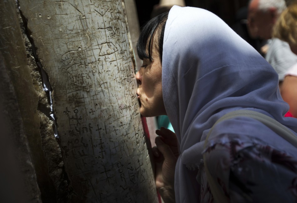 A Christian worshipper kisses a pillar at the entrance to the Church of the Holy Sepulchre in Jerusalems Old City, before the Orthodox Easter service, May 5, 2013.